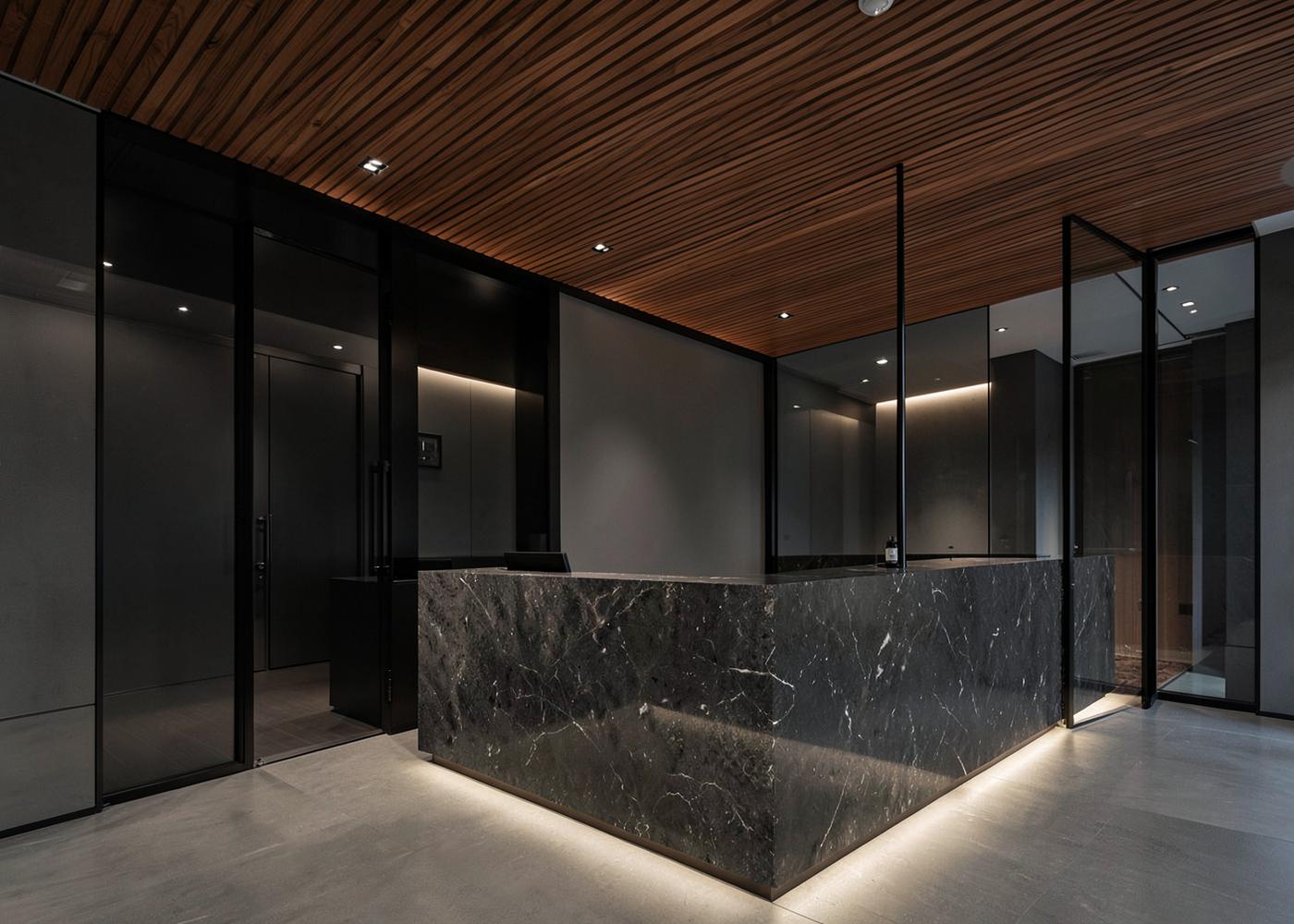 Recepción corporativa con mostrador de piedra e iluminación indirecta